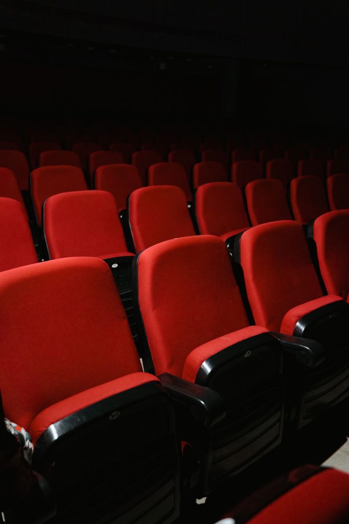 Empty red seats in a dark movie theater