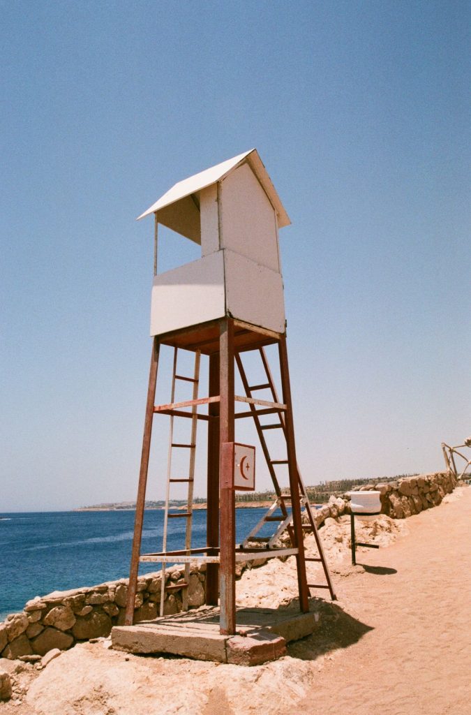 Lifeguard tower on a sunlit rocky shore